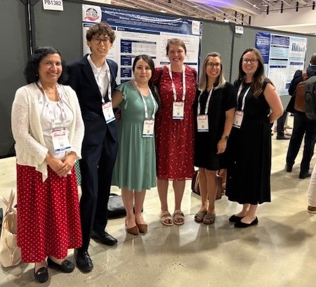 Six people in front of research poster