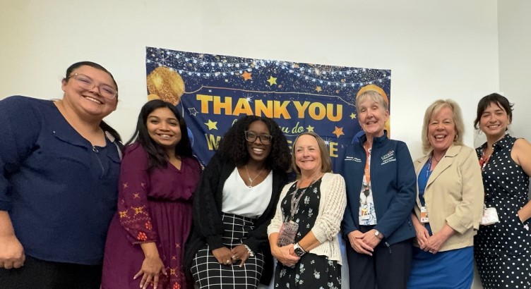 Seven people in front of "thank you" banner