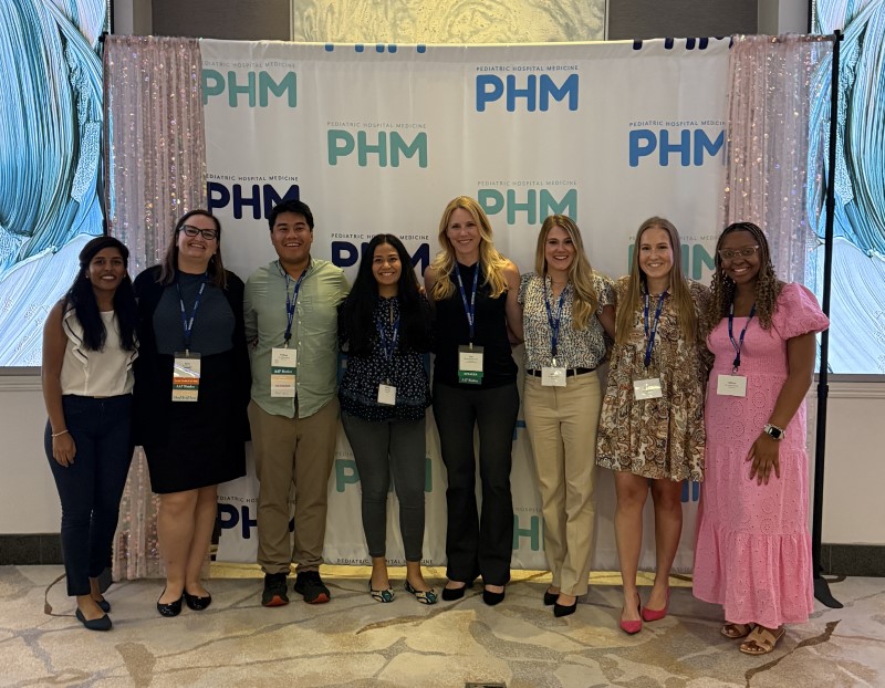 Doctors in front of banner at conference