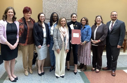 Group of people standing with signed bill