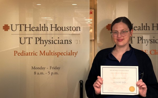 Woman holding certificate in front of office door