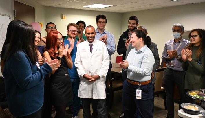 Group applauding doctor in white coat