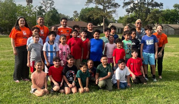 Group of adults and children on a soccer field