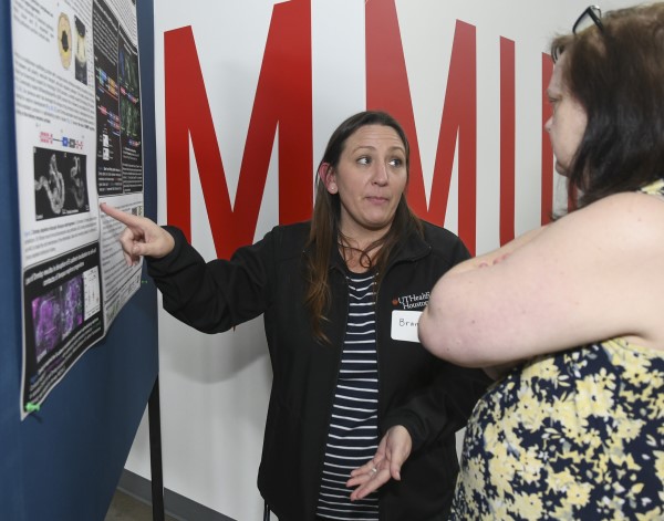 Researcher presenting poster to attendee