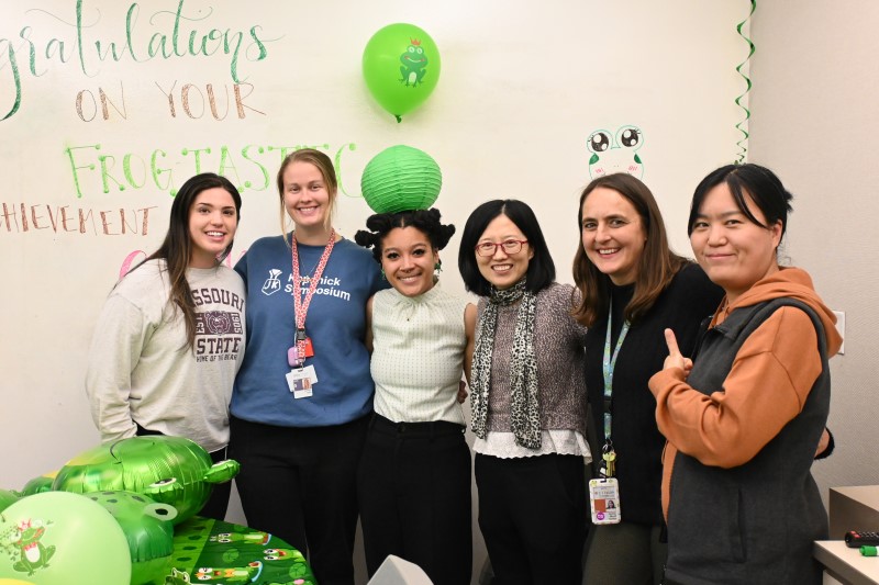 Group of people standing in front of decorated whiteboard