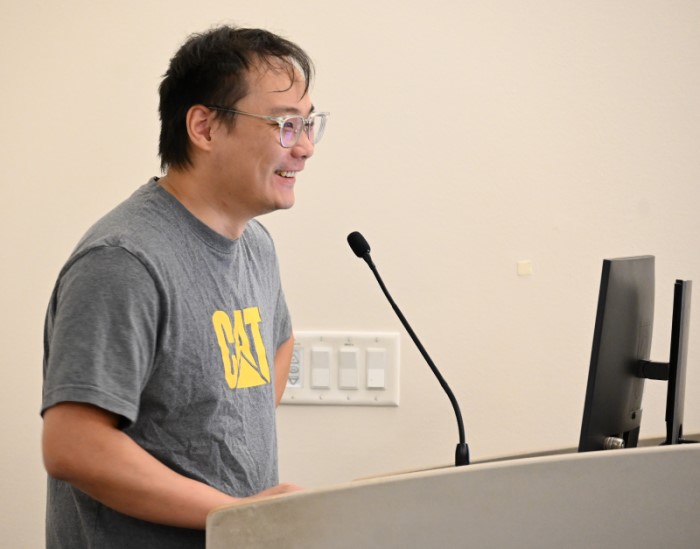 Man at microphone, in front of computer