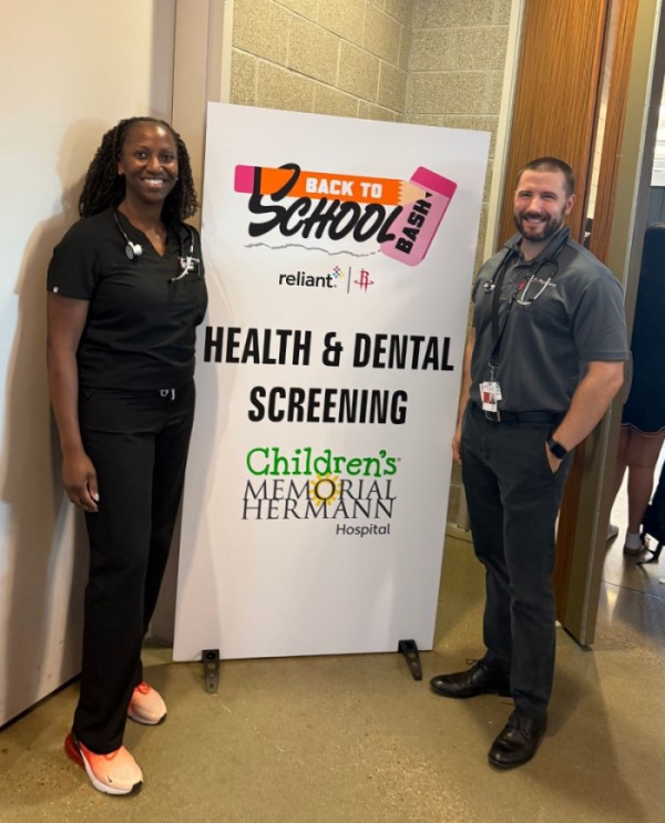 Two doctors standing in front of banner