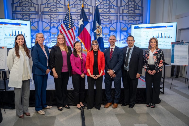 Group of 8 professionals in front of state and country flags