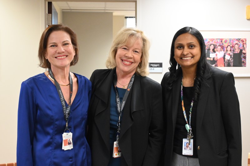 Three women standing and smiling
