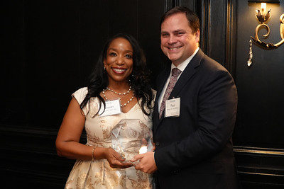 Man and woman pose with glass plaque