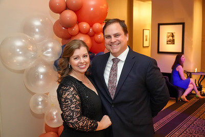 Man and woman posing in front of balloons