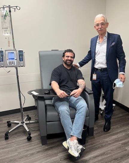 Patient in chair, medical director stands next to him