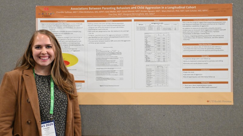 Dr. Sullivan stands in front of research poster