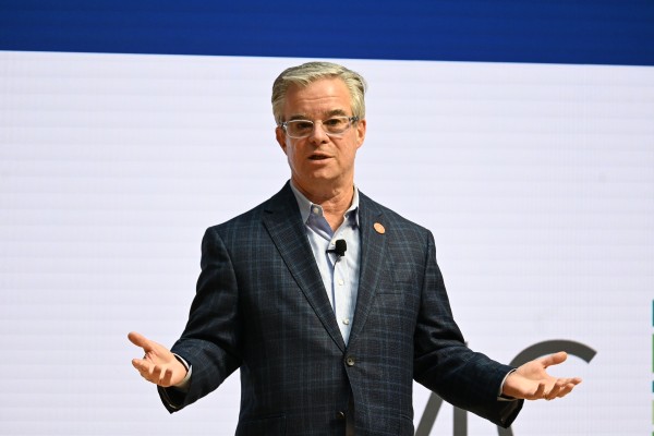 Joshua Horwitz speaking in front of screen, gesturing with hands