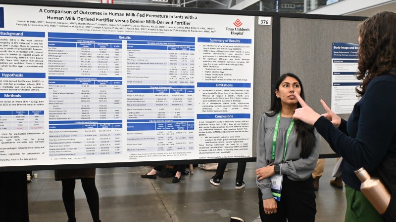 Author discusses research poster with colleague
