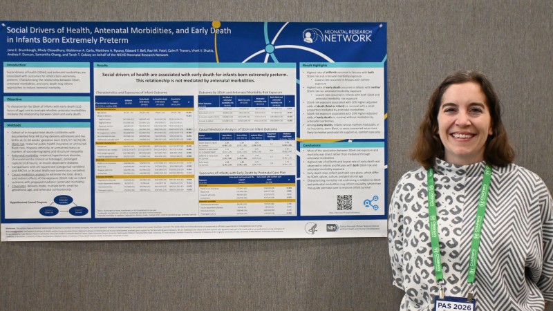 Doctor standing next to a research poster