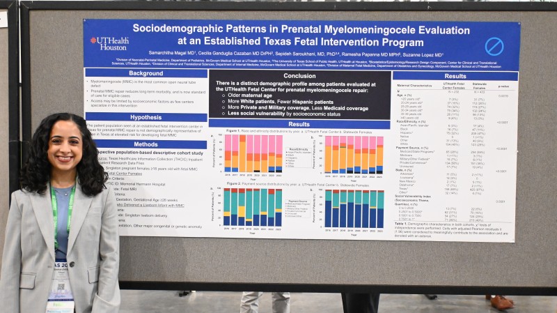 Dr. Magal stands in front of research poster