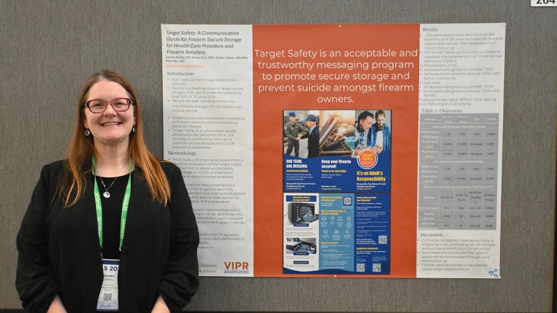 Dr. McKay stands in front of her research poster.