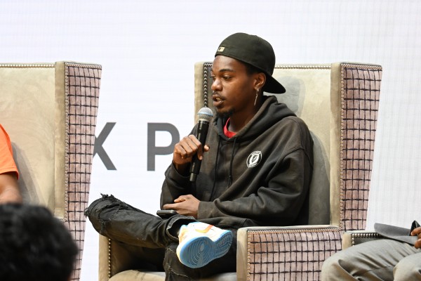 Young man sitting in chair speaking into microphone