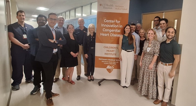 CiCHD lab team and Foundation members around banner
