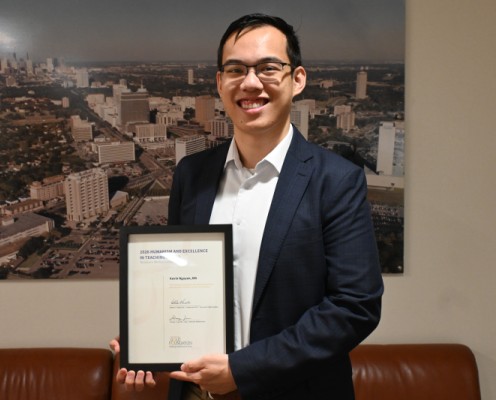 Kevin Nguyen, MD, holds certificate for Humanism Award