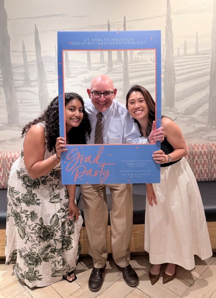 Graduating fellows and program director pose with photo frame