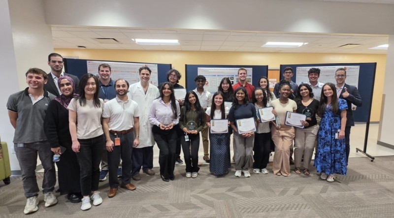 Summer Institute students and team in front of research posters