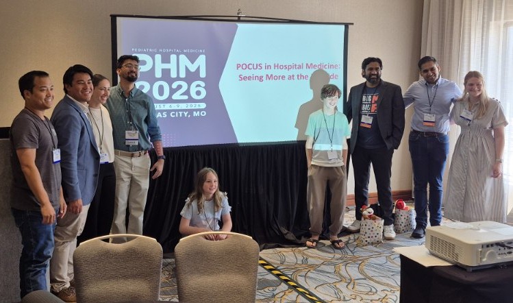 Group of people pose in front of PPT screen
