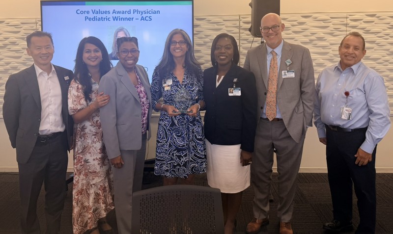 Group of people with Dr. Dharia holding award