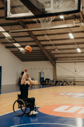 person in wheelchair throwing a basketball