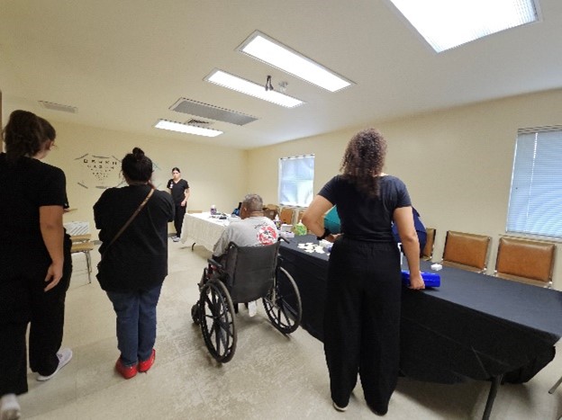 student volunteers helping roll patient in wheel chair