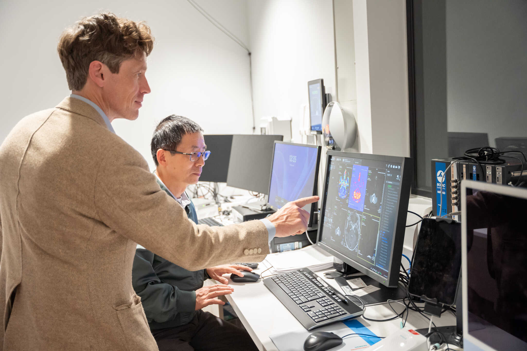 Dr. Kochunov pointing at a MRI scan