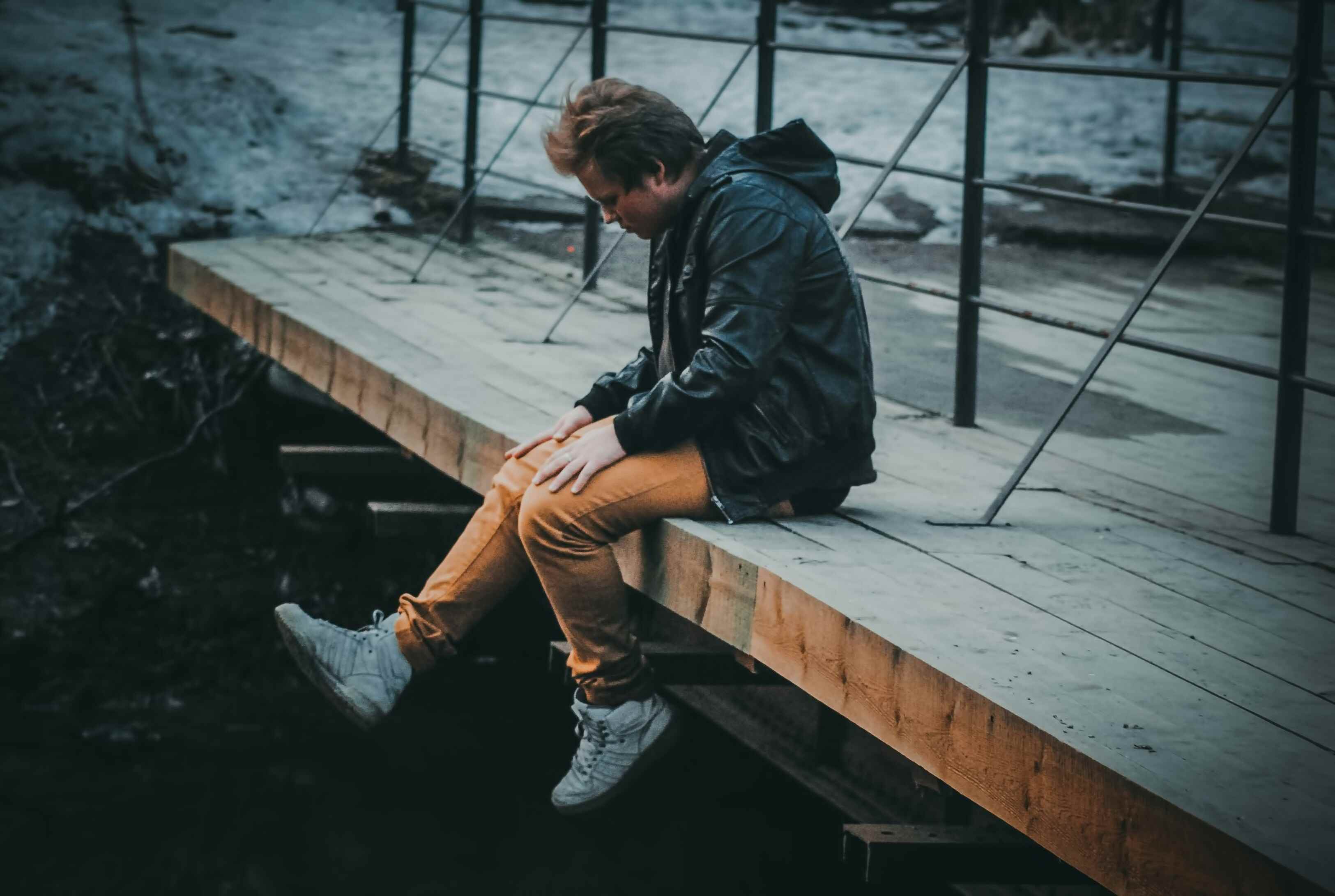 man sitting on bridge 