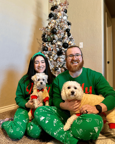 Yuisa and her partner at the christmas tree with her two dogs in matching pjs 