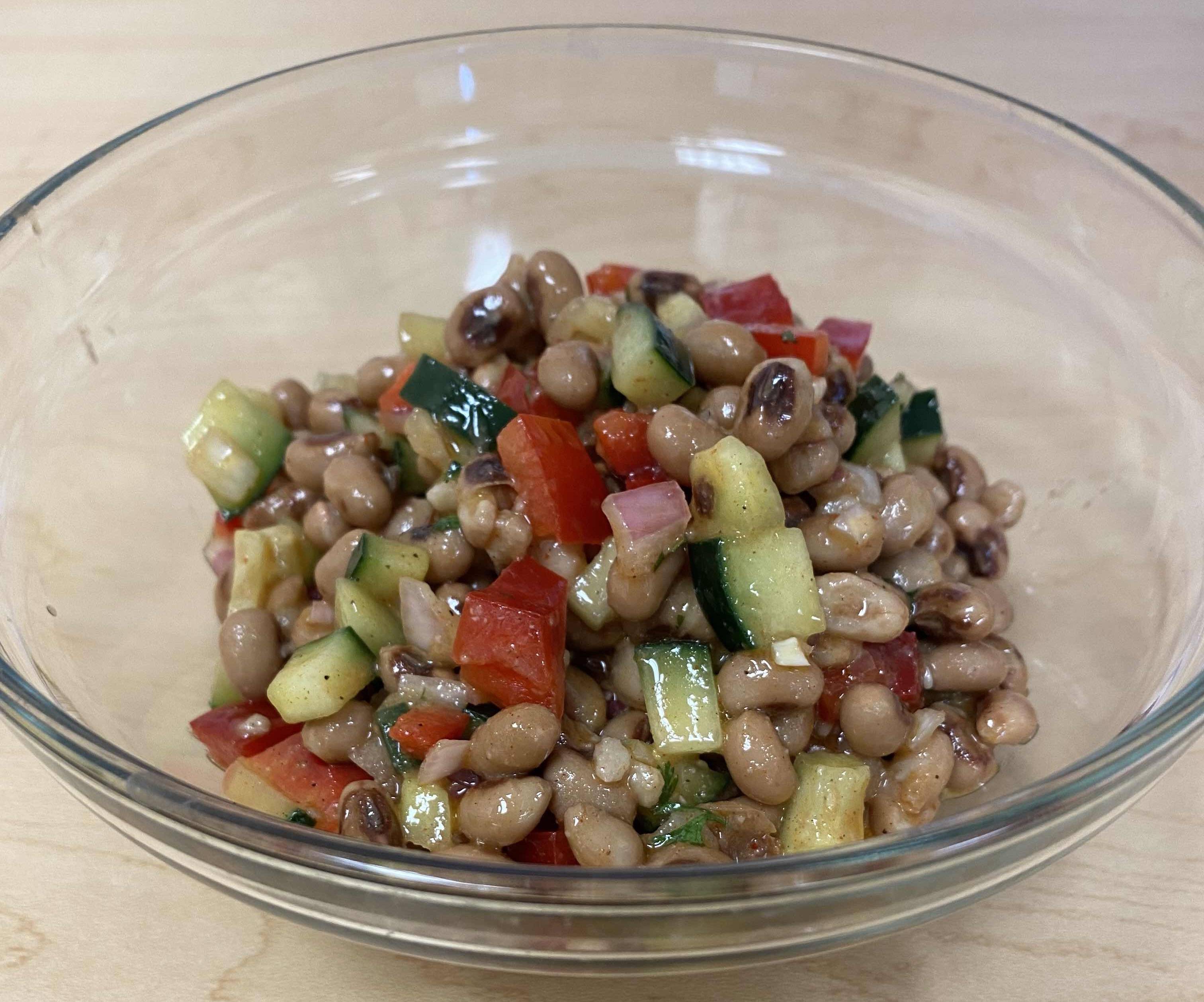 Black-eyed pea salad with tomato and red bell pepper in a clear bowl