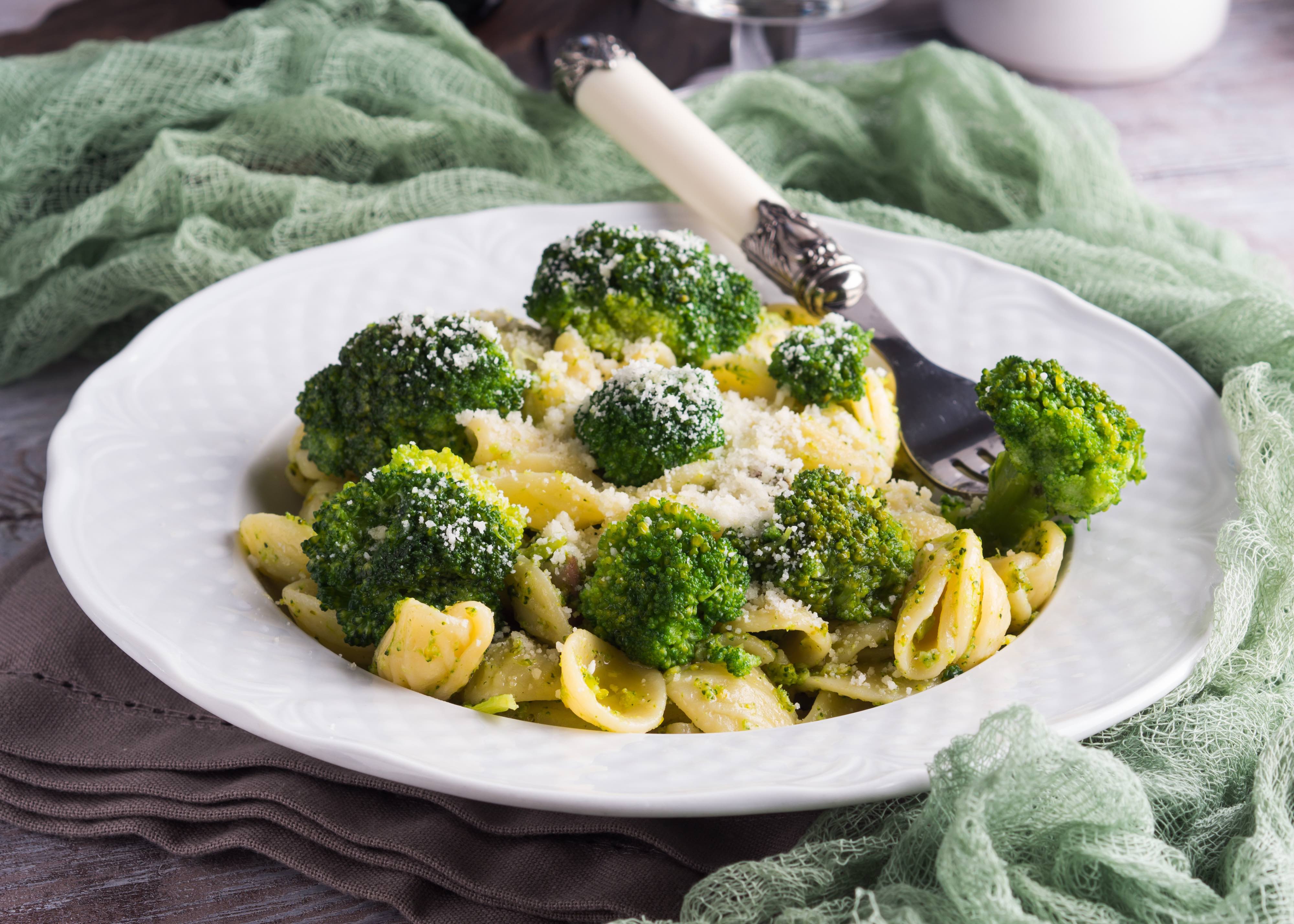 Chicken, broccoli, and shell pasta sprinkled with grated parmesan plated