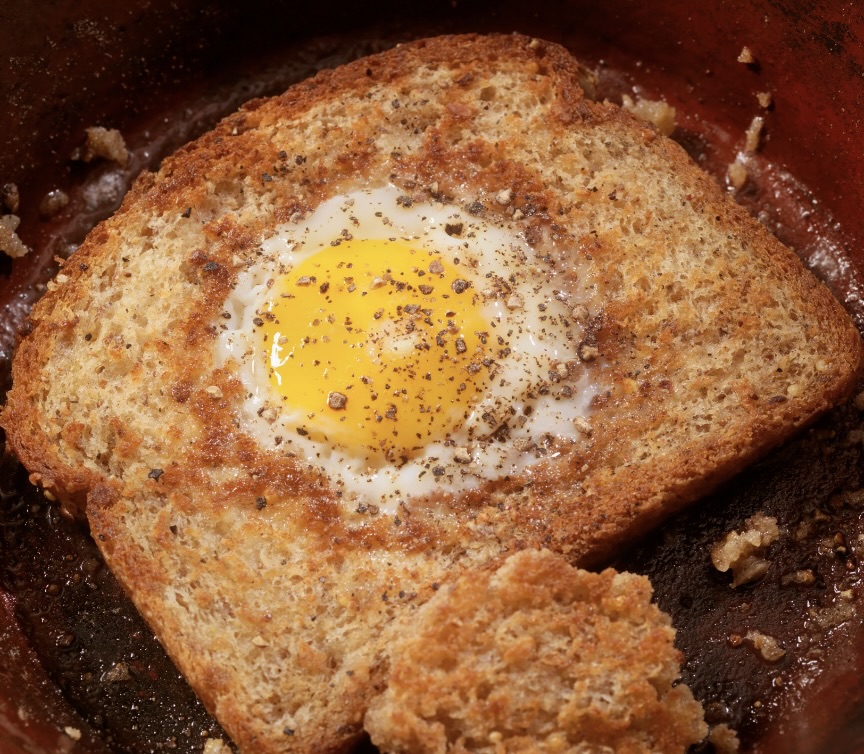 Skillet containing egg in a hole toast