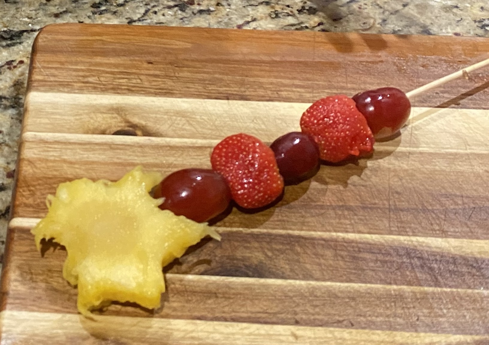 Fruit wand made from pineapple star, watermelon, and grapes