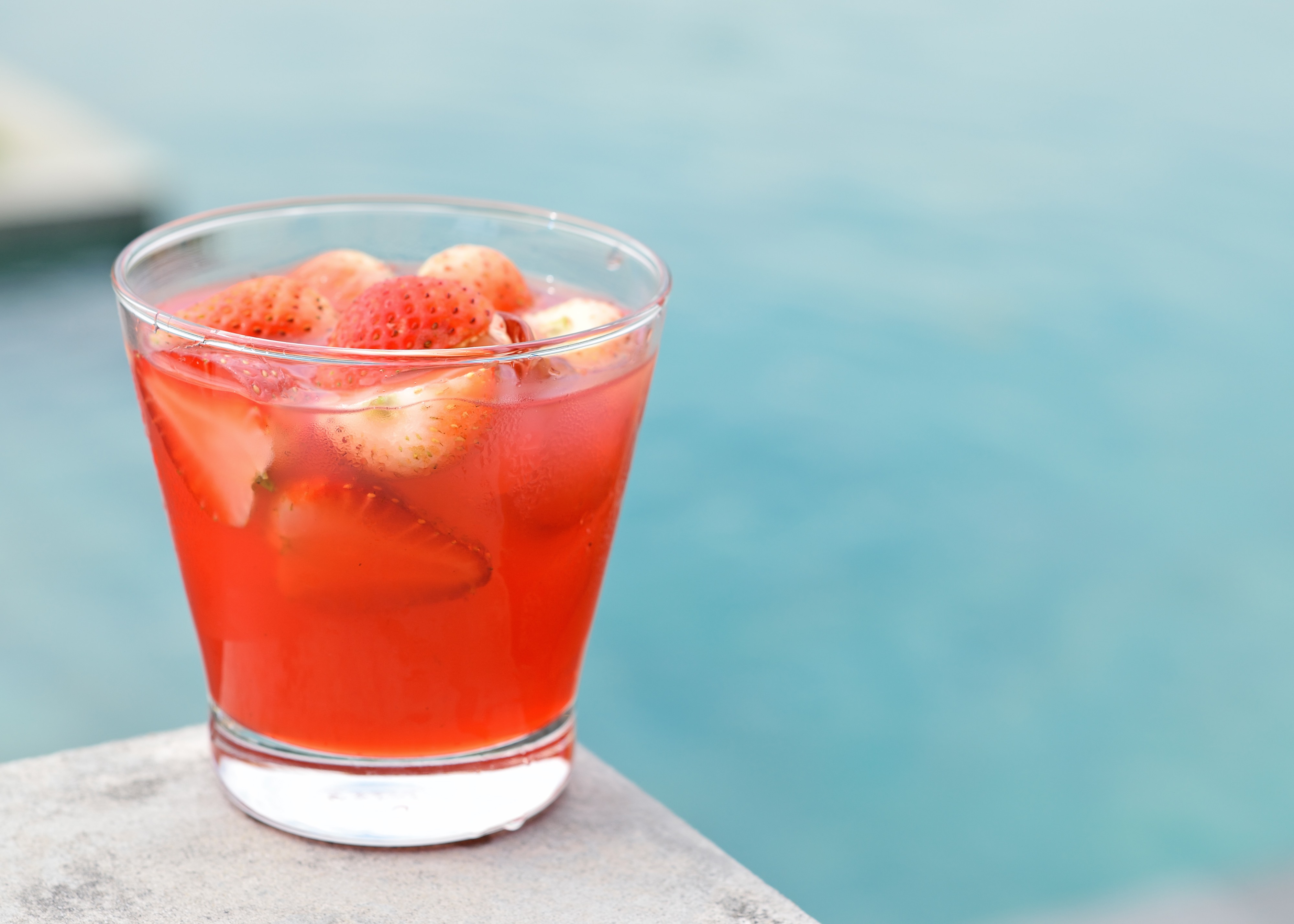 Strawberry swirl beverage on a ledge over a body of water