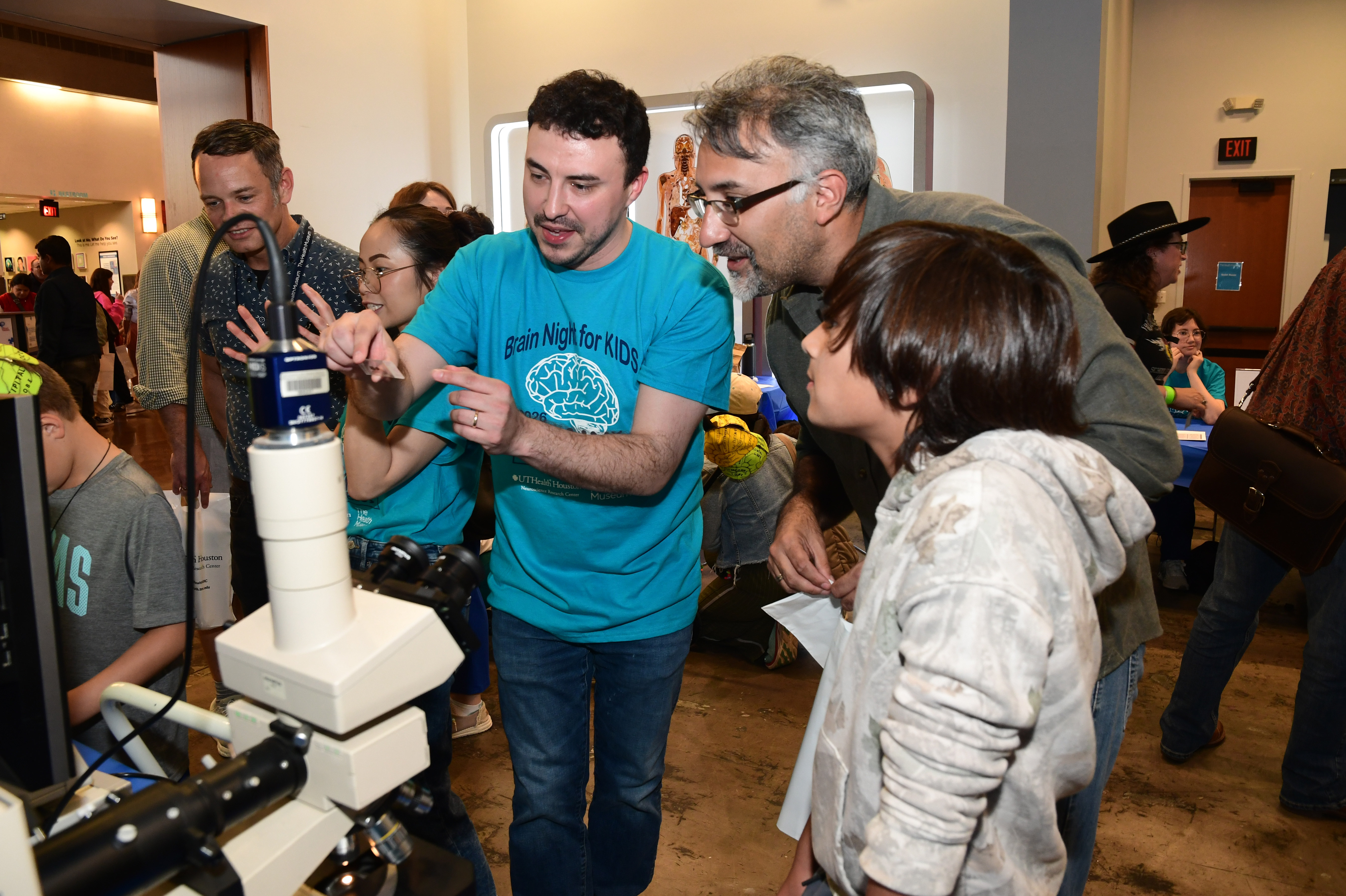 A child learns how to use a microscope at Brain Night for Kids