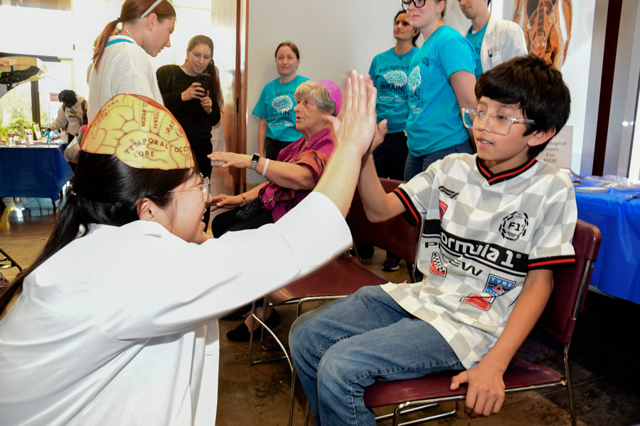 A student high fives a parent at Brain Night for Kids