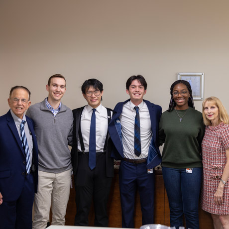 Jim and Debbie Adler pose for a photo with four McGovern Medical School students