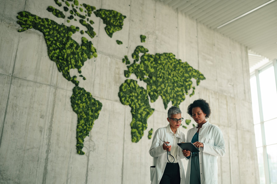 A pair of doctors discusses research in front of a map