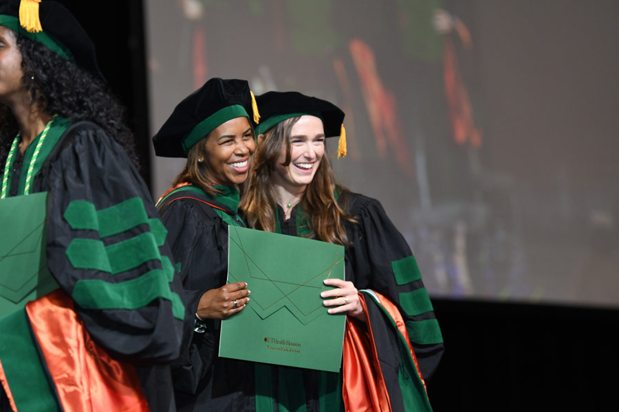 LaTanya J. Love, MD, poses with a graduate after presenting a diploma during commencement ceremonies at NRG Arena.