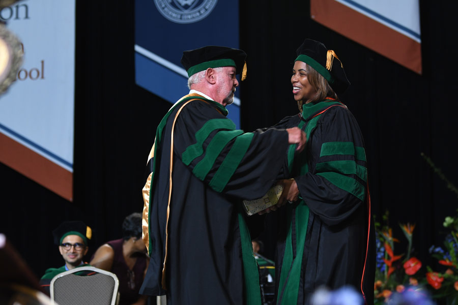 LaTanya J. Love, MD, congratulates an award winner on stage during the McGovern Medical School Class of 2026 Commencement Ceremony.