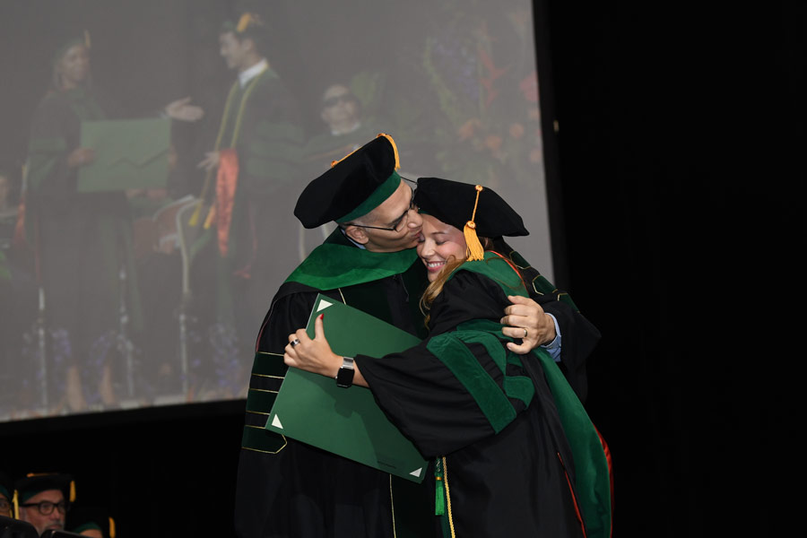A graduate embraces a family member after receiving a diploma during the McGovern Medical School Class of 2026 Commencement Ceremony.