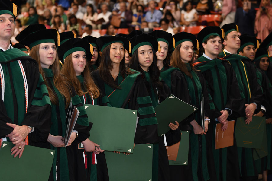 Members of the McGovern Medical School Class of 2026 stand together during the commencement ceremony at NRG Arena.