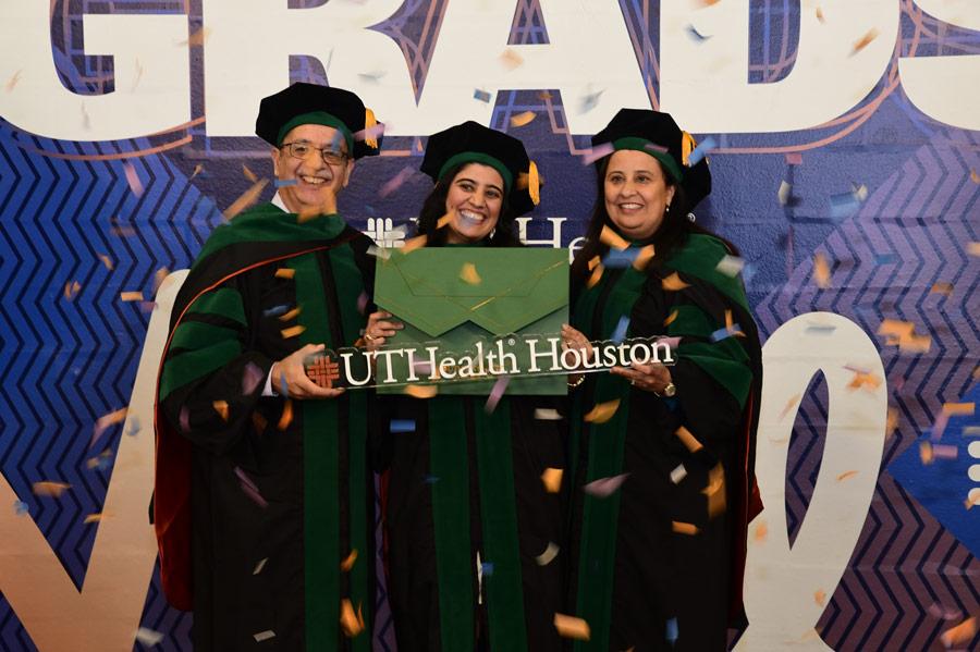 A graduate celebrates with family members beneath falling confetti after the McGovern Medical School Class of 2026 Commencement Ceremony.