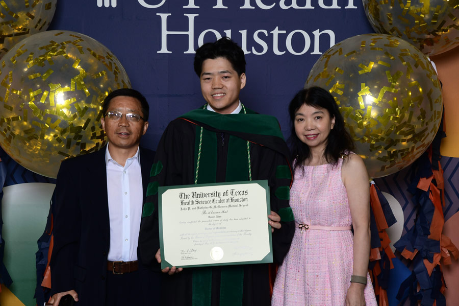 A graduate poses with family members after the McGovern Medical School Class of 2026 Commencement Ceremony.