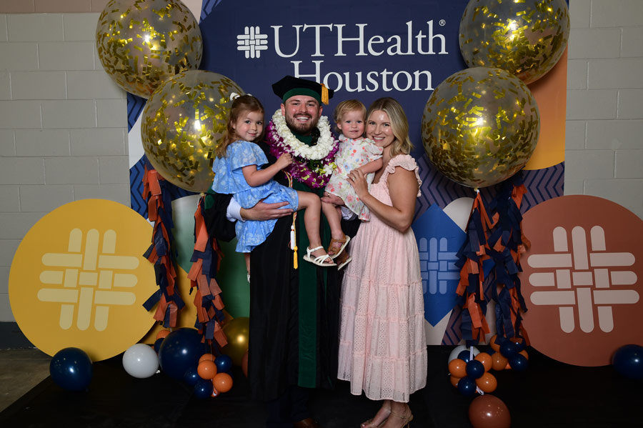 A graduate celebrates with family members following commencement ceremonies at NRG Arena.